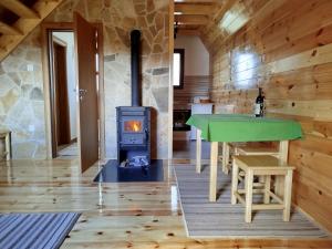 a room with a fireplace and a table and a stove at Brown cabin in Žabljak