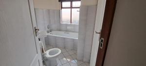 a bathroom with a tub and a toilet and a sink at See Uitsig 16 in Uvongo Beach +5 photos