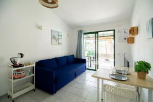 un soggiorno con un divano blu e un tavolo di El Nidito a Maspalomas