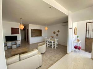 a living room with a couch and a dining room at Apartamento Infantes Playa in Sanlúcar de Barrameda