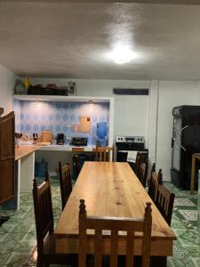 a kitchen with a wooden table and chairs in a room at Mandala’s Hostal in San Pedro La Laguna +35 photos