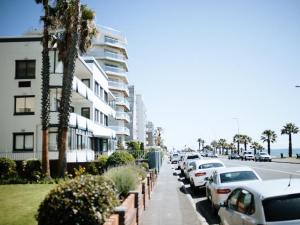a street with cars parked next to a building at Mouille Point Villa Capri in Cape Town