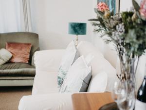 a living room with a white couch and a vase of flowers at Mouille Point Villa Capri in Cape Town +31 photos