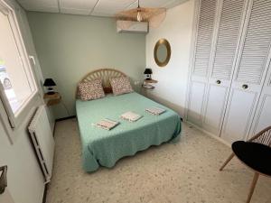 a small bedroom with a bed with a green blanket at Meublé tourisme 4*, les pieds dans l'eau, Villa LAS PALMERAS in La Londe-les-Maures