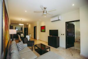 ein Wohnzimmer mit einer Couch und einem Deckenventilator in der Unterkunft EL FARO 204 SURF two bedrooms apartment ocean front in Playa del Carmen
