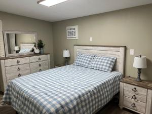 una camera da letto con un letto con una coperta a scacchi e uno specchio di Cottage on Charles a Roxboro