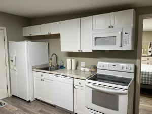 una cucina con armadietti bianchi ed elettrodomestici bianchi di Cottage on Charles a Roxboro