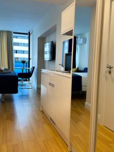 a room with a kitchen and a bedroom with a bed at BATUMI ORBI APARTMENTs in Angisa