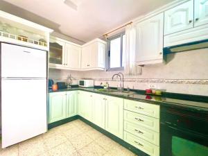 a kitchen with white cabinets and a white refrigerator at Casa Orone in Valle Gran Rey