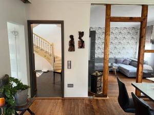 ein Wohnzimmer mit einer Tür, die in ein Wohnzimmer führt in der Unterkunft Sandys Cozy Stone Cottage in Maulbronn