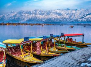 a group of boats parked on the water with mountains at Moonlight Homestay in Srinagar