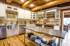 a kitchen with white cabinets and a table with dishes at The Silver Lake Lodge - Adults Only in Idaho Springs