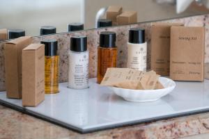a shelf with bottles of essential oils and a bowl at Golden Bay Beach Hotel in Larnaca