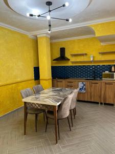 a dining room with yellow walls and a table and chairs at Sunny Days Borjomi in Borjomi