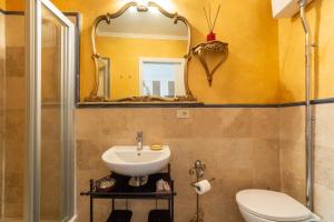 a bathroom with a sink and a toilet and a mirror at BIBI BOUTIQUE AREZZO Camere deluxe Cartazucchero & Cioccolato in Arezzo