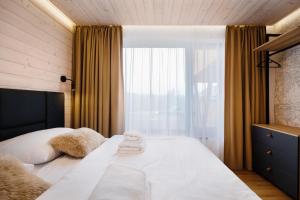 a bedroom with a bed with towels on it at Chalet Wellness TRI VODY Demänovská Dolina in Liptovský Mikuláš