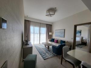 a hotel room with a couch and a table at Vida Marina marassi hotel apartment with extra fees for beach or pool access شقة فندقية عائلات فقط في أوتيل فيدا مراسي مارينا دخول شاطئ البحر او حمام السباحة برسوم إضافية in El Alamein +17 photos