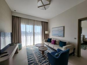 a living room with a couch and a tv at Vida Marina marassi hotel apartment with extra fees for beach or pool access شقة فندقية عائلات فقط في أوتيل فيدا مراسي مارينا دخول شاطئ البحر او حمام السباحة برسوم إضافية in El Alamein