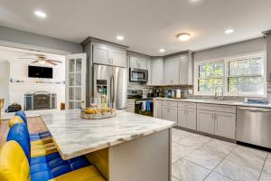 a kitchen with white cabinets and a large island at Spacious Home with Hot Tub, 14 Mi to Downtown ATL! in Union City