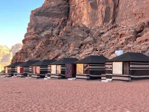 a row of buildings in front of a mountain at Wadi Rum Story Camp in Wadi Rum
