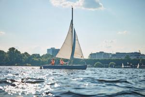 two people on a sail boat on the water at Hotel Atlantic Hamburg, Autograph Collection in Hamburg