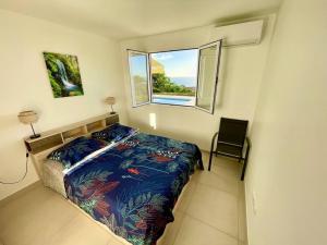 una piccola camera da letto con un letto e una finestra di Magnifique villa 6 à 8 pers avec piscine - vue mer a Vieux-Habitants