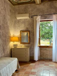 a bedroom with a bed and a window at Le Ginestre in San Gimignano +4 photos