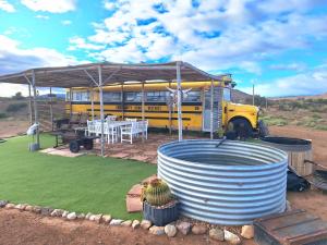 a yellow bus with a picnic table in front of it at Yellow Karoo school bus in Ladismith