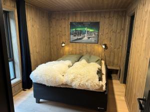 Un dormitorio con una cama cubierta de piel blanca. en Roaldsida Retreat, en Stranda