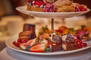a plate of desserts and pastries on a table at Hotel Atlantic Hamburg, Autograph Collection in Hamburg
