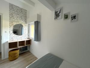 a bedroom with a bed and a mirror on the wall at Gîte des 4 saisons in Rupt-sur-Moselle