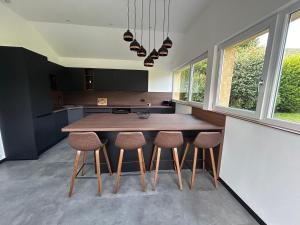 a kitchen with a wooden table and stools at Gîte des 4 saisons in Rupt-sur-Moselle