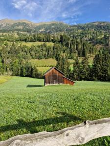 a barn in a field with a wooden fence at Tiny House Waldschmied 1 in Latzendorf
