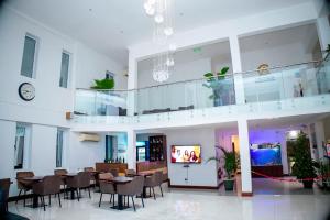 a dining room with tables and chairs and a clock at Cromer Apartment Hotel in Accra