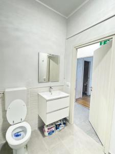 a bathroom with a toilet and a sink and a mirror at Romoli Rooms and suites in Rome