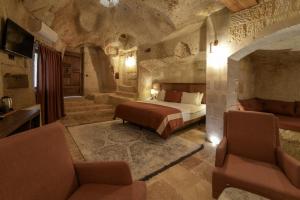 a bedroom with a bed and two chairs and a couch at Henna Hotel-Adults Only in Goreme +100 photos