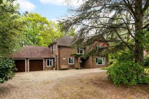 a brick house with a garage and a driveway at Delux 5 bed house lots private car parking, short walk to high st, shops in Fleet