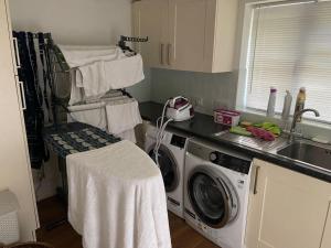 a kitchen with a washing machine and a sink at Delux 5 bed house lots private car parking, short walk to high st, shops in Fleet