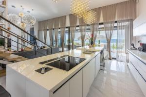 una cocina con una gran isla con encimera en Luxusvilla mit Infinity-Pool, Wellnessbereich, 1 km zum Strand, en Crikvenica
