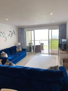 ein Wohnzimmer mit einer blauen Couch und einem Fernseher in der Unterkunft 30 Bredon Court Newquay Sea view in Newquay
