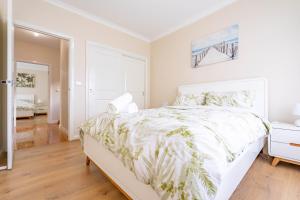 a white bedroom with a large bed with a white bedspread at Hidden Gem - 3 bedroom townhouse in Heidelberg West in Melbourne