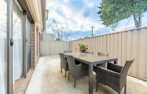 a table and chairs on a patio with a fence at Hidden Gem - 3 bedroom townhouse in Heidelberg West in Melbourne
