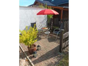 a patio with a table and a red umbrella at Ferienwohnung Krentz in Neu Sallenthin