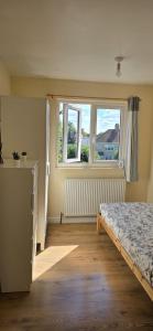 un dormitorio con una cama y una ventana en Private Rooms near Hither green Station, en Londres