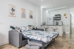 a bedroom with a bed and a kitchen at Canteras 1º Linea de Playa in Las Palmas de Gran Canaria