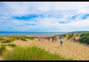 a group of people standing on a beach at Dune Horizon - Camber Sands, East Sussex in Camber +3 photos