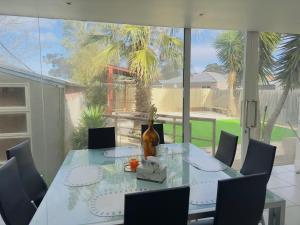 威勒比3 BR villa in Werribee near to Werribee CBD的餐桌、椅子和花瓶