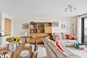 a living room with a table and a couch at B6 Masts - With sea views, parking and terrace in Torquay +22 photos