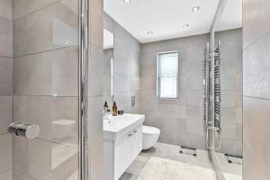 a bathroom with a shower and a toilet and a sink at B6 Masts - With sea views, parking and terrace in Torquay