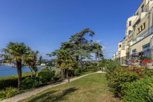 a building with trees and flowers next to the water at B6 Masts - With sea views, parking and terrace in Torquay